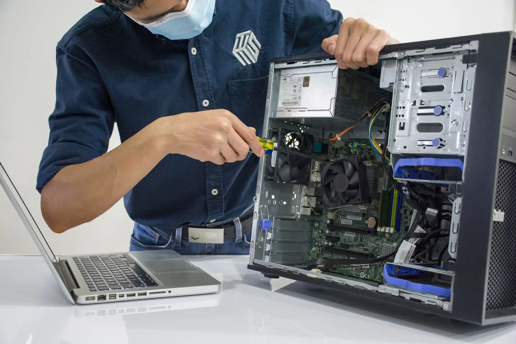 Technician working inside an open desktop computer