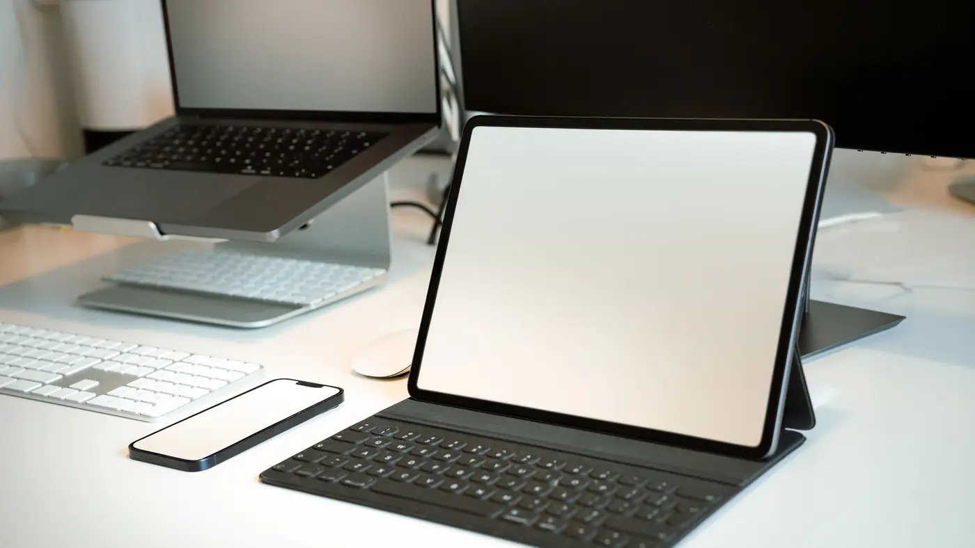 A laptop, tablet and phone set up on a bright desk ready for security testing