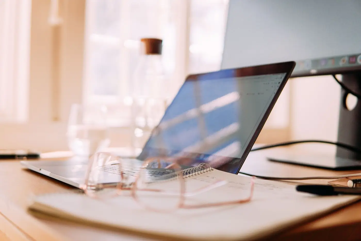 A laptop and monitor on a bright home office desk