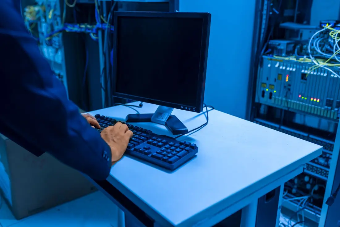 IT professional working at a computer in a server room